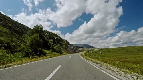 Vehicle Shot of Asphalt Road Going Through Hills on Cloudy Day in Montenegro Nature