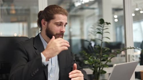 Office Worker in Formal Clothes Having Video Conference on Laptop at Workplace