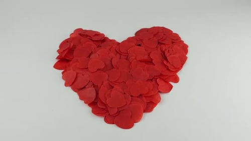 Confetti fly and make a heart shape. Slow motion.