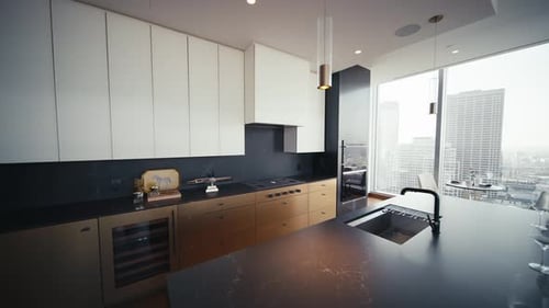 luxury kitchen with dark wood and black accents with white cabinets in a luxury condo building, wide