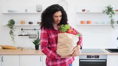 Woman with Groceries in Kitchen