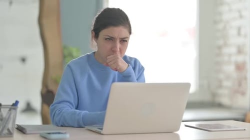 Inderin hustet bei der Arbeit am Laptop
