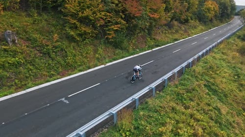 Drone Aerial View a Professional Cyclist Man Rides a Rural Road Next to Fields Beautiful Nature