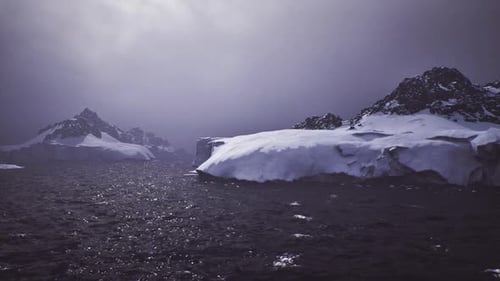 Cinematic Flight Over Icy Ocean with Snowy Mountains
