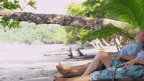 Couple Laying on Chairs at Beach American