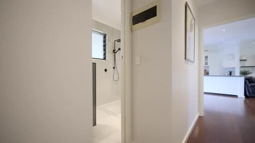 Hallway of contemporary modern house into luxurious bathroom. grey tiles, white vanity basin and bla