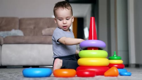 Un precioso niño caucásico construye una pirámide de juguete. Niño feliz que crece y se desarrolla.