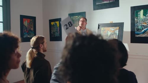 Auctioneer Conducting Fine Art Auction in Gallery