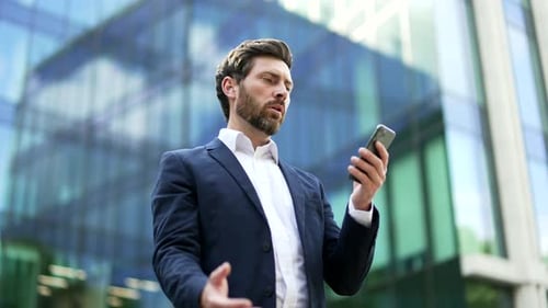 Worried Businessman Using Cellphone Outside Office