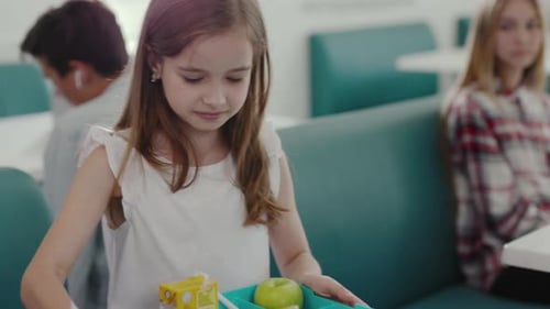 Un niño disfruta de una colorida y nutritiva bandeja de almuerzo llena de opciones saludables en la escuela