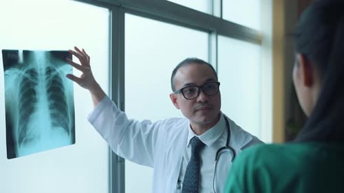 Doctor Explains X-Ray to Colleague in Hospital