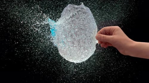 Explosión de un globo de agua después de un piercing con una aguja afilada