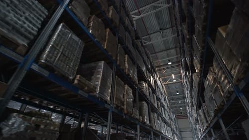 Forklifts move cardboard boxes inside a contemporary cargo mail warehouse interior