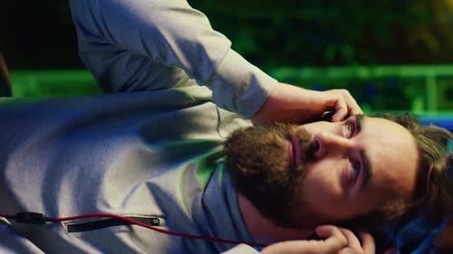 Vertical Video Close Up Shot of Man Putting Headphones on While Playing Videogames at Home