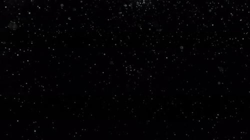 Real snow falling slightly to the left in front of a black background