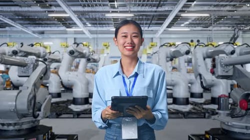 Engineer Controls Robotic Arms in a Modern Factory