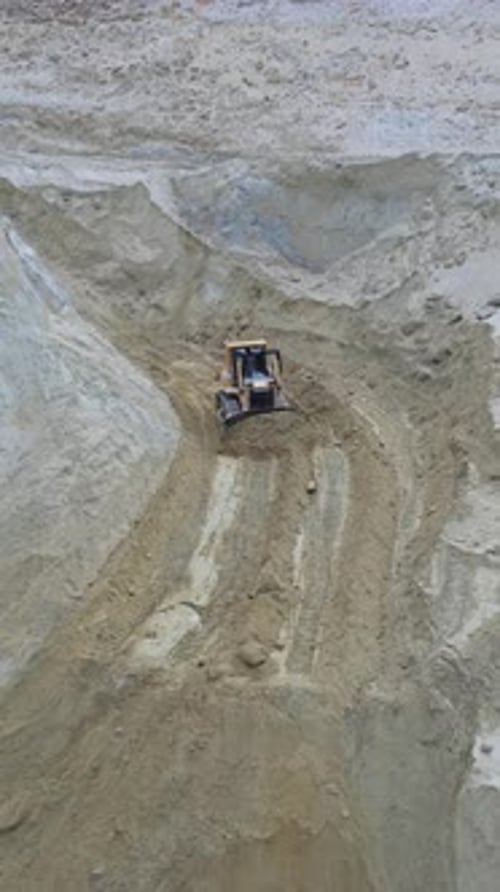 Heavy Tractor Moving Across Sand Quarry From Above