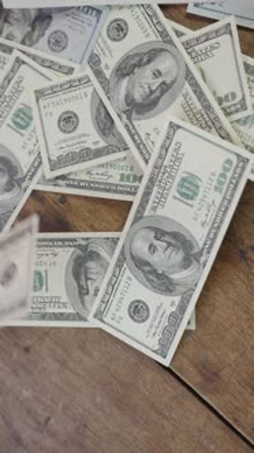 Schwebende Dollars, die einen Holztisch bedecken