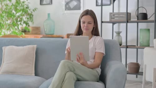 Woman Looks at Tablet with Confused Frustrated Expression