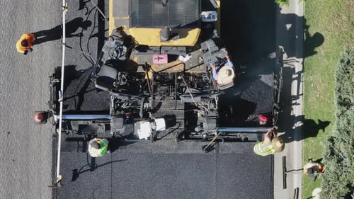 Asphaltpflasterverfahren mit Arbeitern und Maschinen