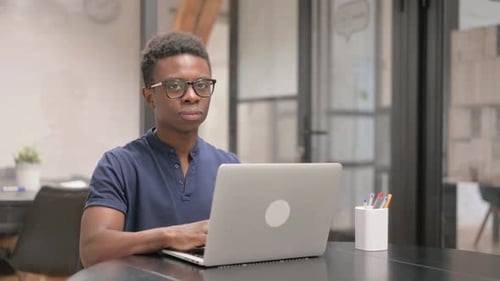 Young Adult Working on Laptop in Office