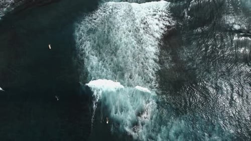 Aerial View of Surfer Riding Waves in the Ocean