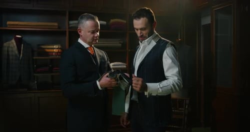 Cinematic shot of young businessman is choosing fabrics of his new custom tailored suit with desig