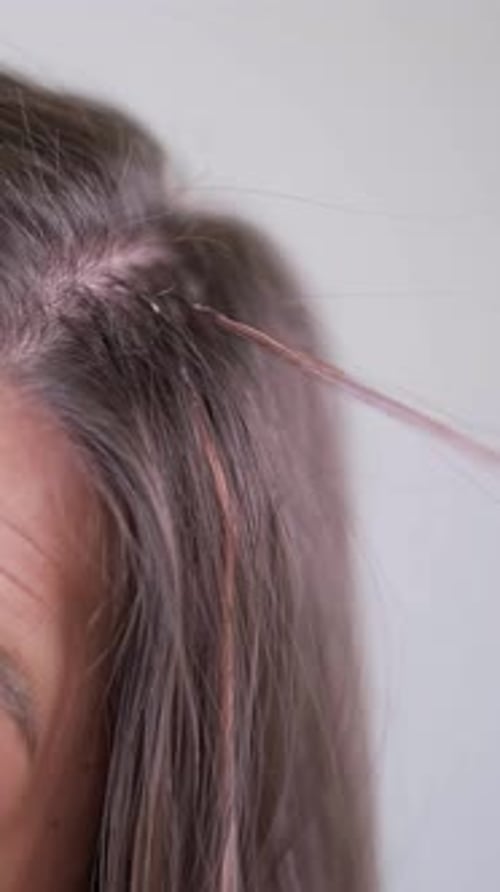 Mulher com extensões de cabelo compridas mostrando mechas lisas e cuidados de salão após tratamento de beleza profissional
