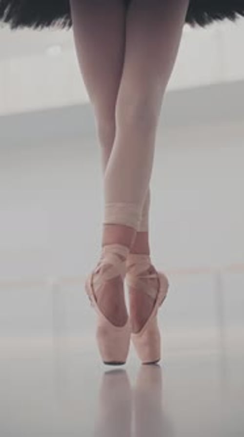 Close-up Shot of Ballerina's Legs. She Dances on Her Pointe Ballet Shoes. Slow Motion.Vertical video