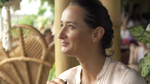 Young woman enjoys refreshing cocktail at trendy outdoor cafe on sunny day