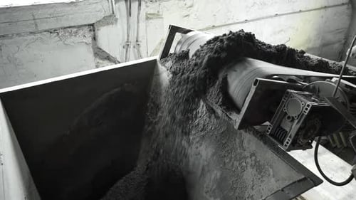 Close up of conveyor belt with crushed stone, shooting in slow motion.