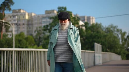 Portrait of Old Bearded Caucasian Man with Gray Hair Walking in Slow Motion in City Leaving