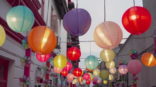 Narrow street is decorated with colorful pinwheels and lanterns