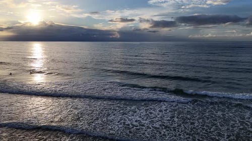 Surfing at Sunset Aerial Views of Surfers Riding Waves Beautifully