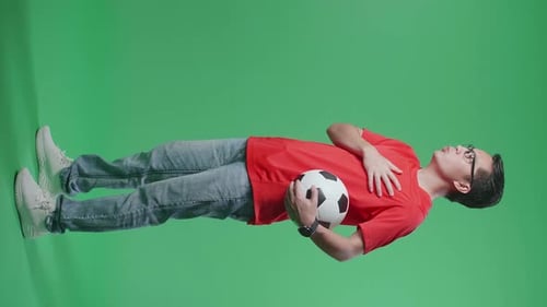 Full Body Of Asian Man With A Ball Singing National Anthem While Cheering Soccer On Green Screen