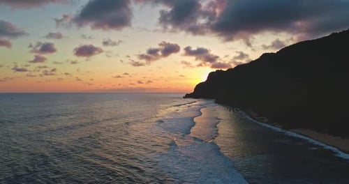 Sunset Illuminating Breaking Ocean Waves Near Bali Cliffs in Indonesia