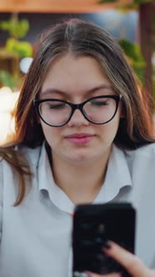 Smiling Lady Using Phone in Cozy Indoor Space with Decorative Lights
