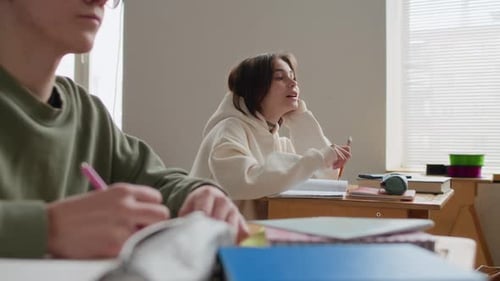 Middle School Students Taking Notes at Their Desks in Modern Classroom