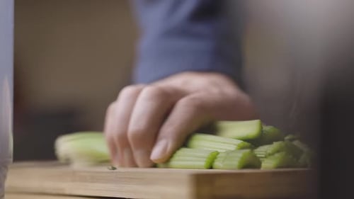 Plan rapproché d'un concombre tranchant à la main sur une planche à découper