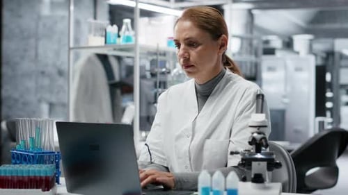Scientist Working in Lab on Laptop with Headache