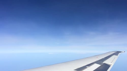 Plane Wing, Moving Clouds, and Horizon