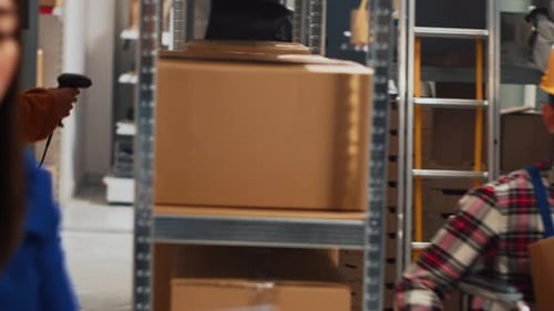 Young Adult in Wheelchair Moving Boxes in Storehouse
