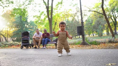 Baby takes First Steps as Parents Cheer in Park