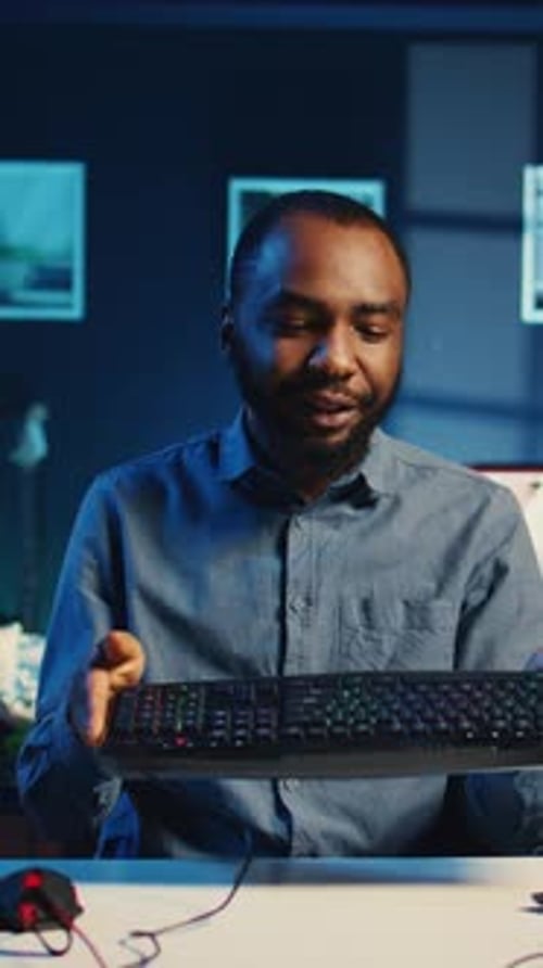 Young Adult Presents Computer Equipment at Desk