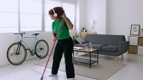 Woman Dancing and Sweeping the Floor at Home