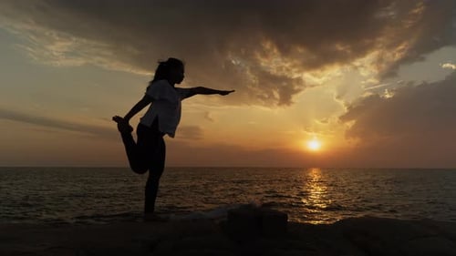 Frau praktiziert Tänzerin Pose Yoga bei Sonnenuntergang am Meer — Silhouette Balance Meditation