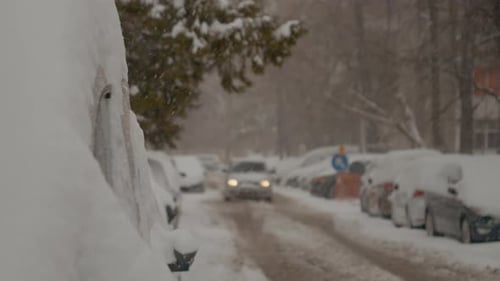 Snow blankets the city streets while cars navigate winter conditions