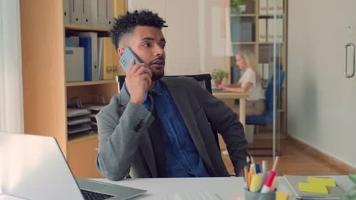 Young Office Manager Talking on Phone during Deal with Client