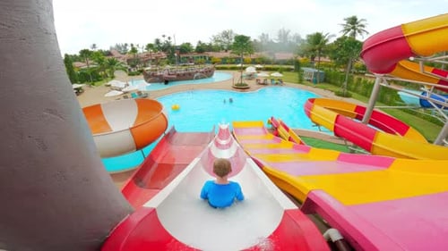 Back View Of A Boy Sliding On A Water Slide
