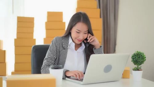 Woman Working on Laptop and Talking on Phone